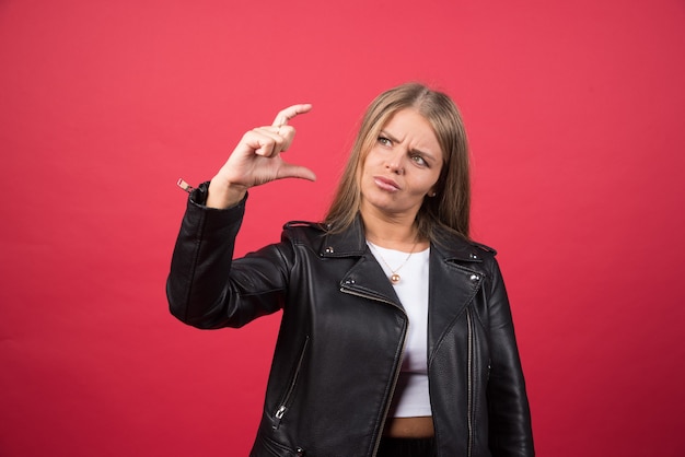 Une jeune femme montrant quelque chose de petit avec les mains