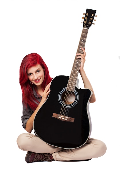 Photo gratuite jeune femme montrant sa guitare