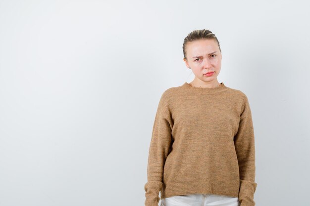 La jeune femme montre qu'elle n'est pas d'accord avec quoi que ce soit sur fond blanc