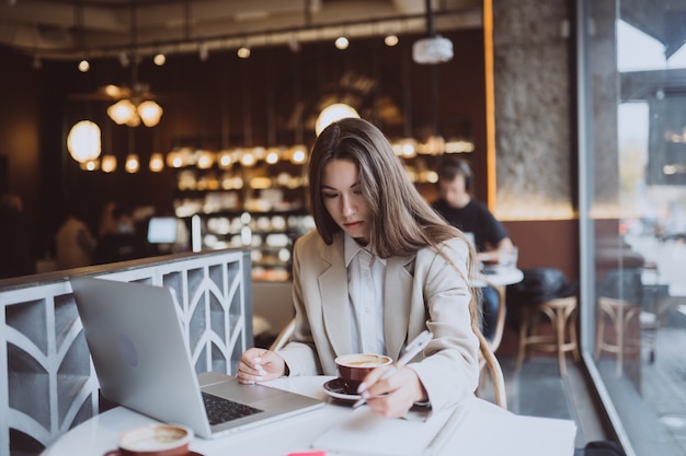 Jeune femme naviguant sur Internet au café