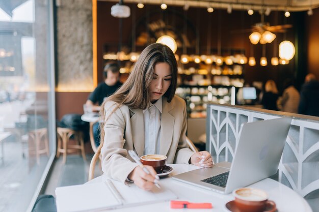 Jeune femme naviguant sur Internet au café