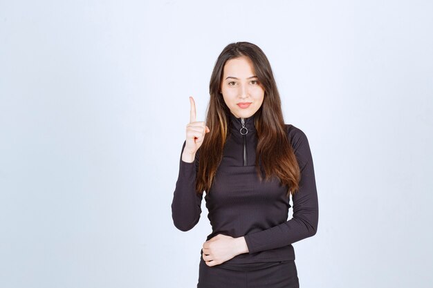 Jeune femme en noir pensant et essayant de comprendre