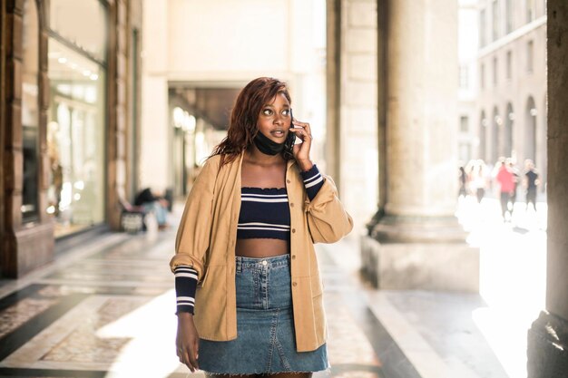 jeune femme noire au téléphone dans la rue