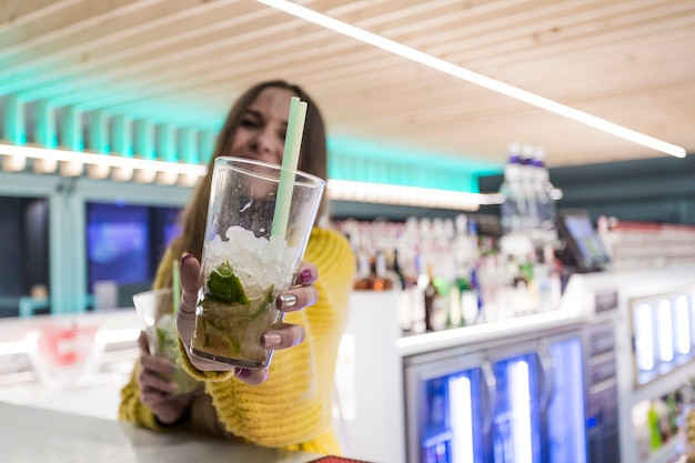 Jeune femme offrant une boisson