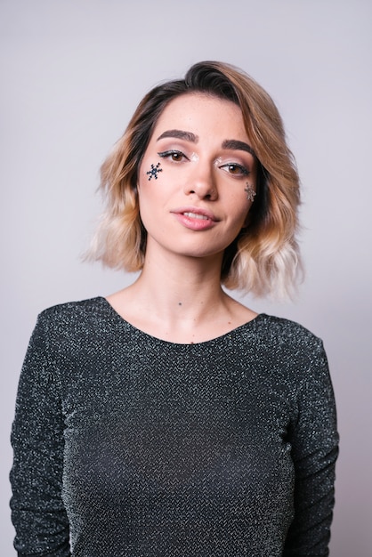 Jeune femme avec des paillettes de flocon de neige sur le visage