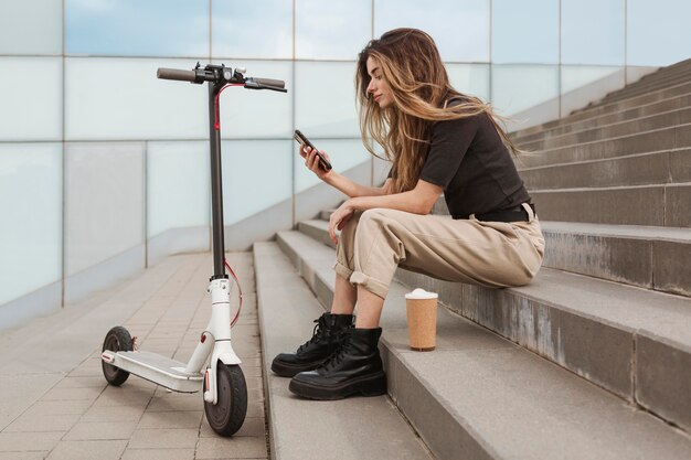 Jeune femme parcourant son téléphone mobile