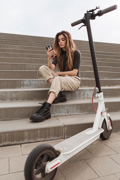 Jeune femme parcourant son téléphone mobile