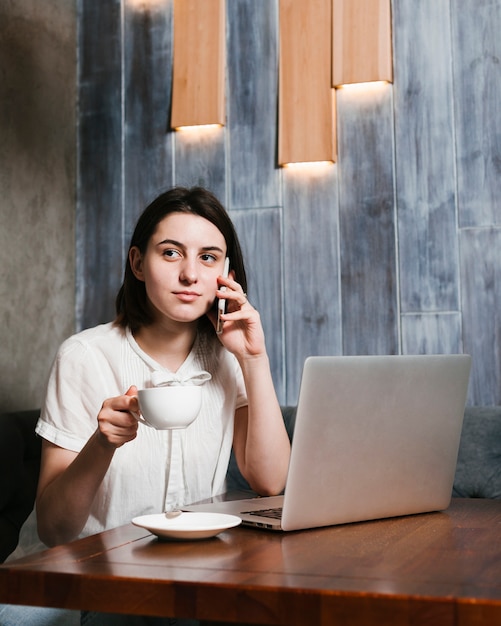 Jeune femme parlant au téléphone au bureau