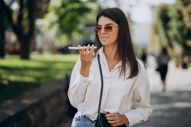 Jeune femme parlant au téléphone à l'extérieur de la rue