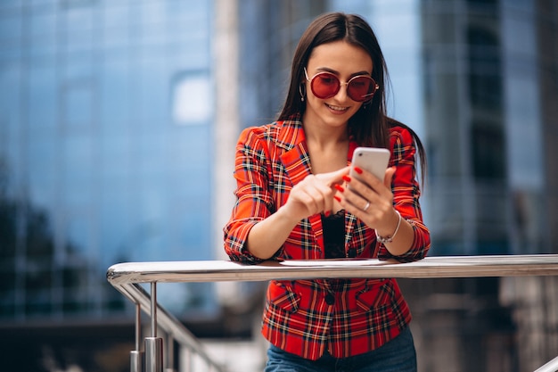 Jeune femme parlant au téléphone près du bureau