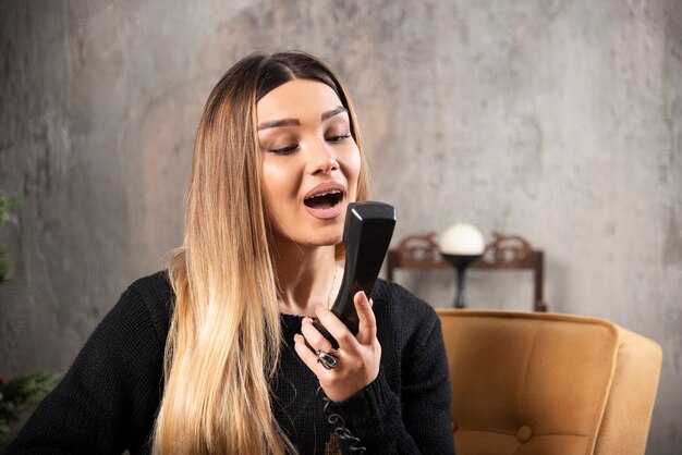 Jeune femme parlant avec bonheur par téléphone.