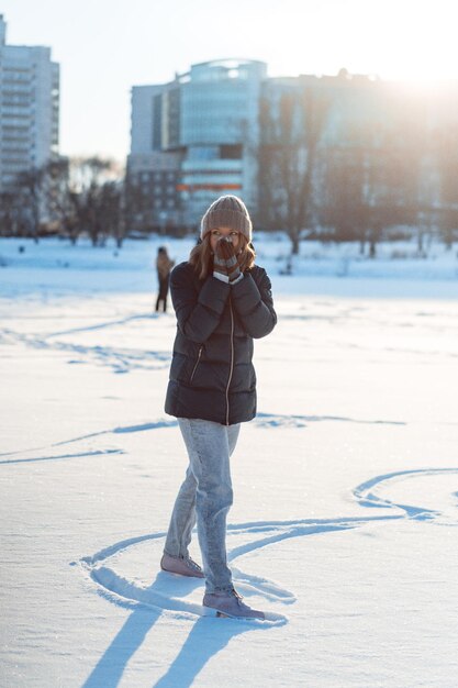 Jeune femme patinage sur glace, sports d'hiver, neige, plaisirs d'hiver. Femme apprenant à patiner sur le lac, nature, journée ensoleillée.