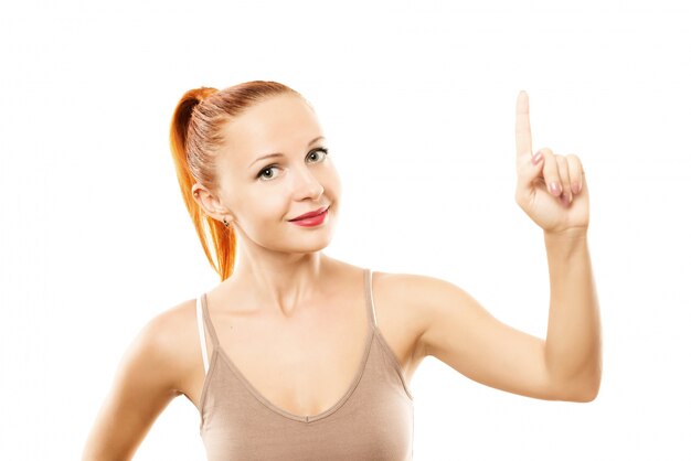 Jeune femme avec une peau saine pointant vers le haut