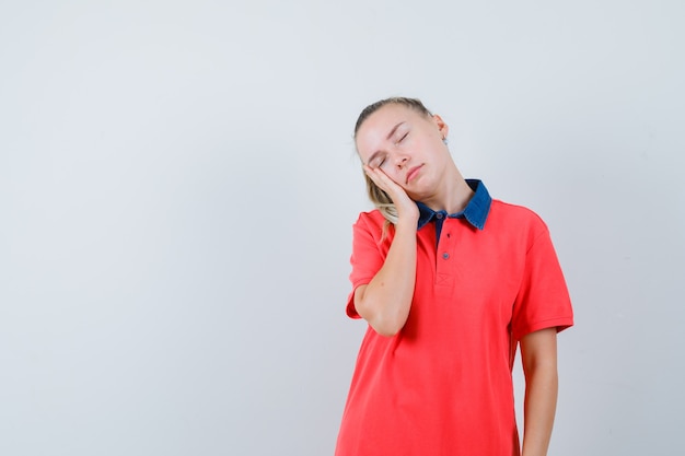 Jeune femme penchée joue sur la paume surélevée en t-shirt et à la somnolence