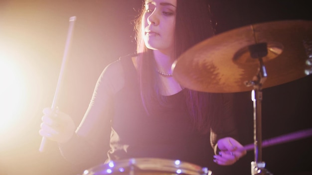 Jeune femme percussionniste jouant avec des tambours, gros plan