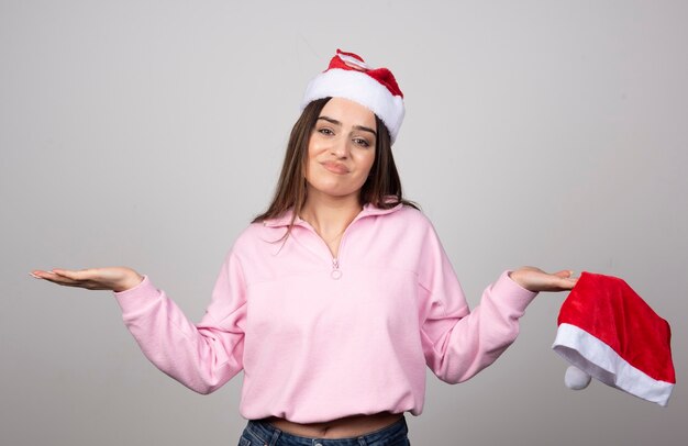 Jeune femme perplexe avec les bras haussant les épaules.