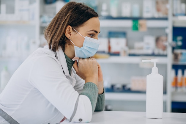 Jeune femme pharmacien désinfectant les mains avec désinfectant