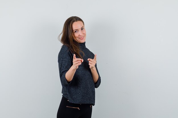 Jeune femme pointant la caméra en chemise