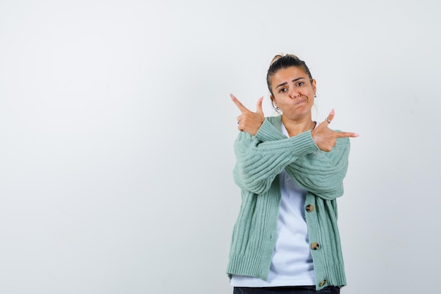 Jeune femme pointant de côté en t-shirt, veste et à la joyeuse