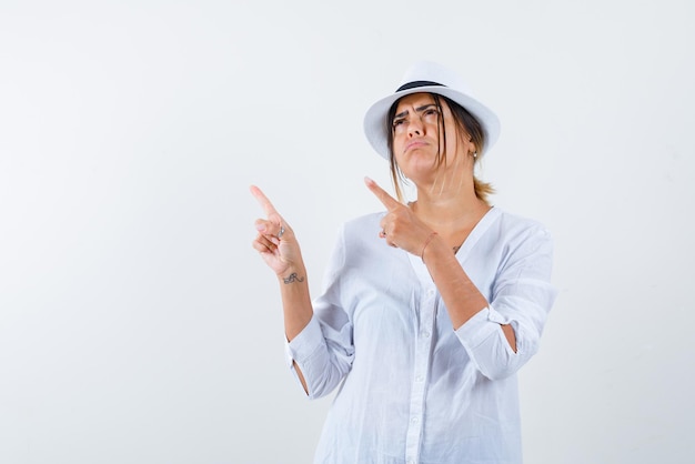 Jeune Femme Pointant Quelque Chose Avec Les Mains Sur Fond Blanc