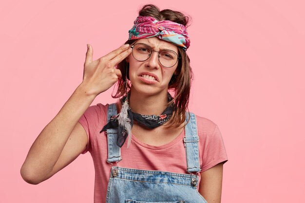 Jeune femme portant un bandeau coloré et une salopette en denim