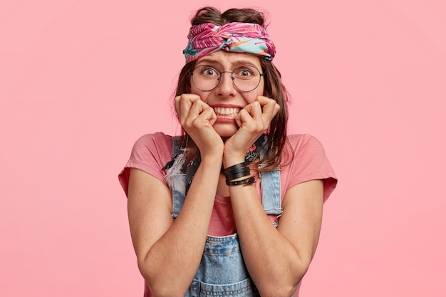 Jeune femme portant un bandeau coloré et une salopette en denim