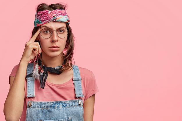 Jeune femme portant un bandeau coloré et une salopette en denim