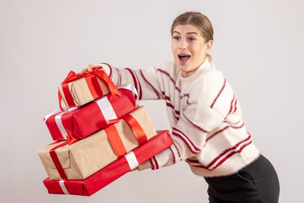 jeune femme portant des cadeaux de Noël sur blanc