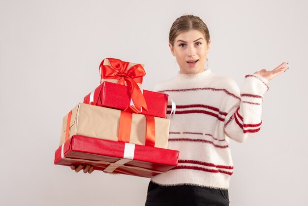 jeune femme portant des cadeaux de Noël sur blanc