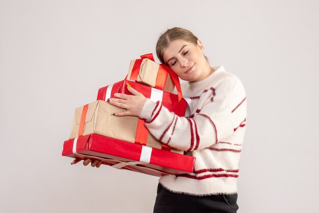 jeune femme portant des cadeaux de Noël sur blanc