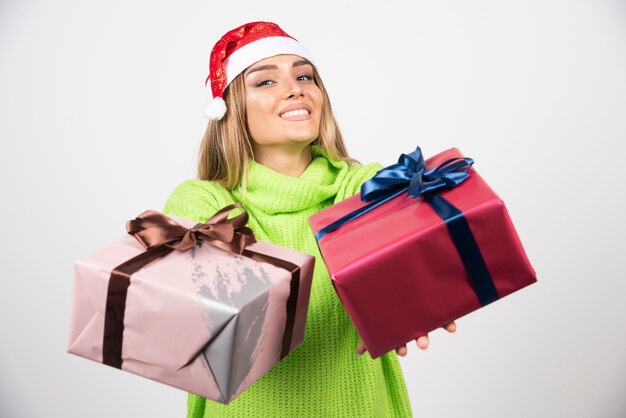 Photo gratuite jeune femme portant des cadeaux de noël festifs.