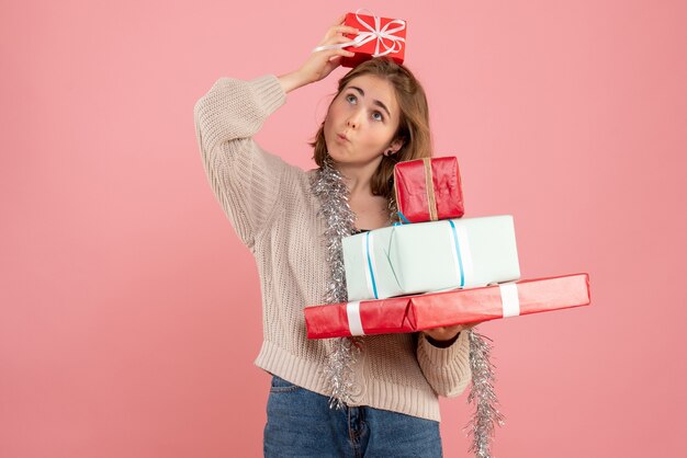 jeune femme portant des cadeaux de Noël sur rose