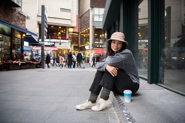 Photo gratuite jeune femme portant un chapeau de seau dans la ville