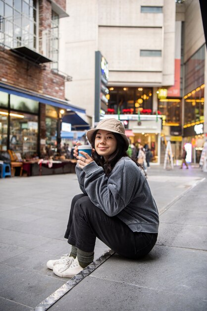 Jeune femme portant un chapeau de seau dans la ville