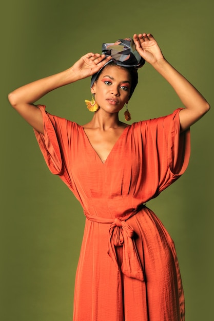 Photo gratuite jeune femme portant une robe orange avec turban et bijoux ethniques