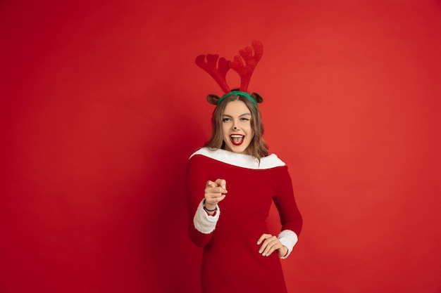 Jeune femme portant une robe Santa sur fond rouge