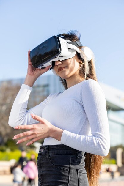 Jeune femme porte des lunettes de réalité virtuelle dans la rue Photo de haute qualité