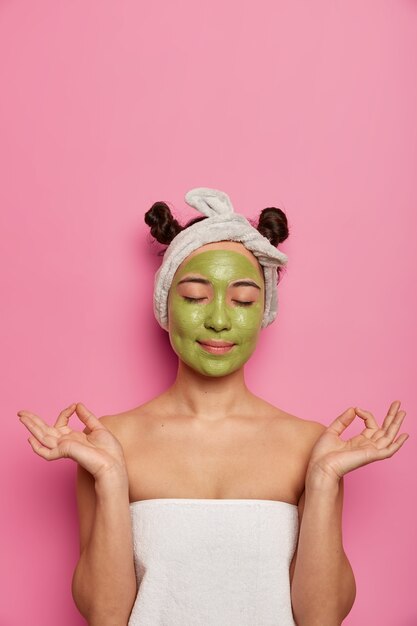 Jeune femme porte des traitements de la peau masque facial naturel après avoir pris un bain