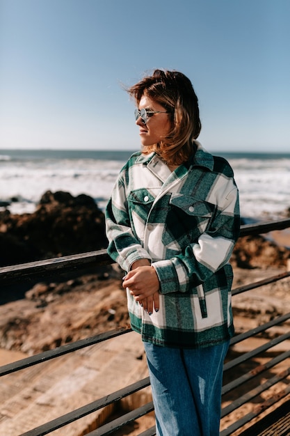 Jeune femme, porter, chemise denim, à, lunettes soleil, poser, plage