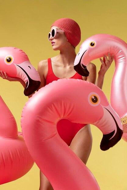 Jeune femme posant avec anneau de natation flamingo