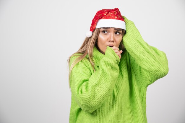 Jeune femme posant au chapeau rouge du père Noël.