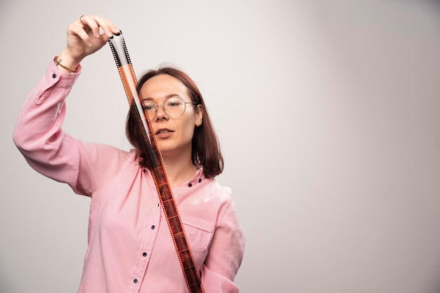 Jeune femme posant avec une bande photo sur un fond blanc. photo de haute qualité