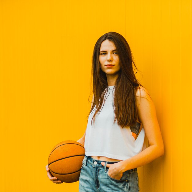 Jeune femme posant avec basketball