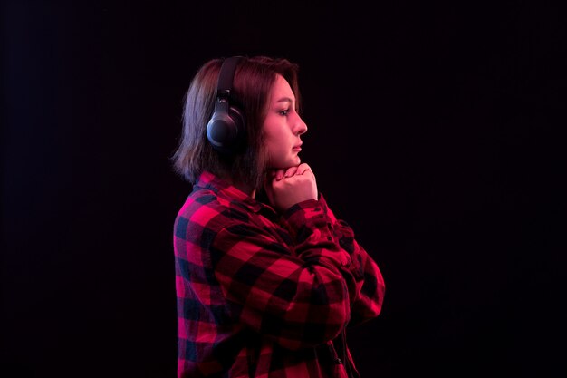 Jeune femme posant avec chemise à carreaux rouge et noir