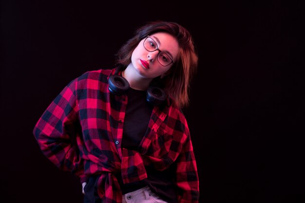 Jeune femme posant avec chemise à carreaux rouge et noir