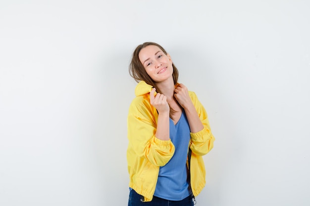 Jeune femme posant debout en t-shirt, veste et magnifique