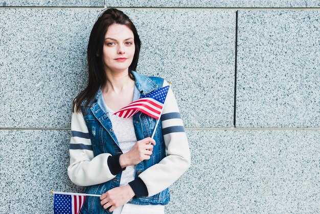 Jeune femme posant avec des drapeaux américains