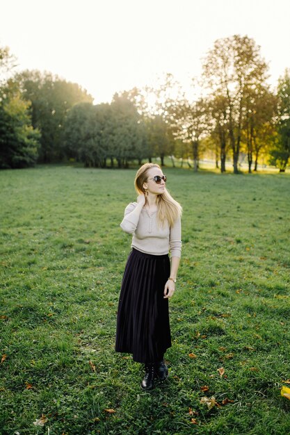 Jeune femme posant sur des feuilles jaunes dans le parc de l'automne. Extérieur