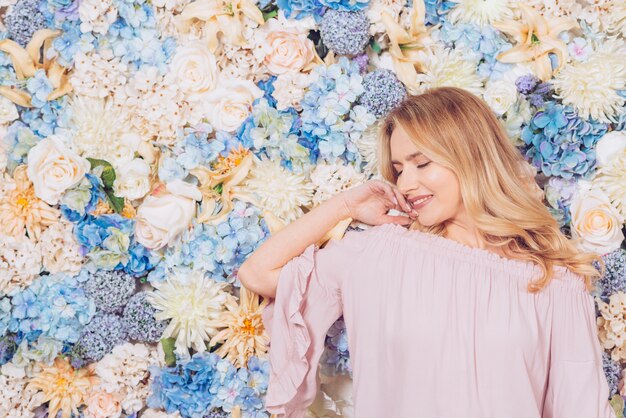 Jeune femme posant sur fond de fleurs