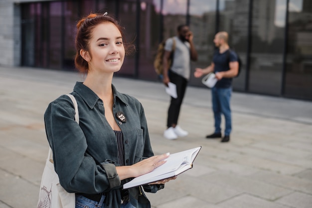 Jeune femme posant avec un livre